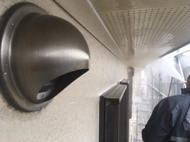 換気フード周辺の高圧洗浄。外壁だけでなく付帯部の汚れも徹底的に落とし、塗装の準備を整える様子