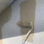 名張市のモルタル外壁塗装で中塗りを行う様子 外壁の耐久性を高める工程