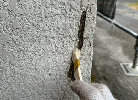 伊賀市U様邸 ひび割れの溝にプライマーを塗布する様子