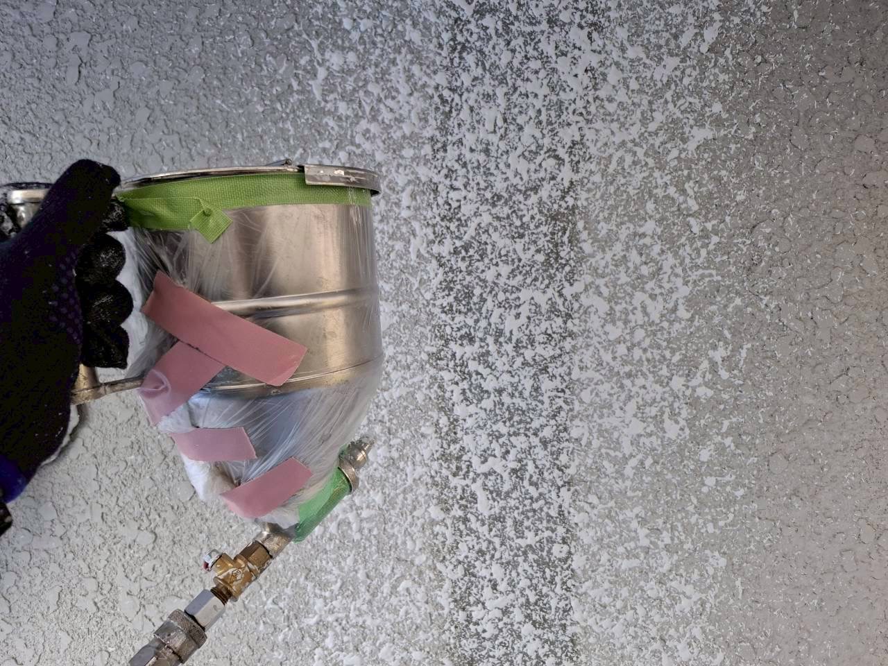伊賀市U様邸 既存の柄に合わせて塗材を吹き付ける様子