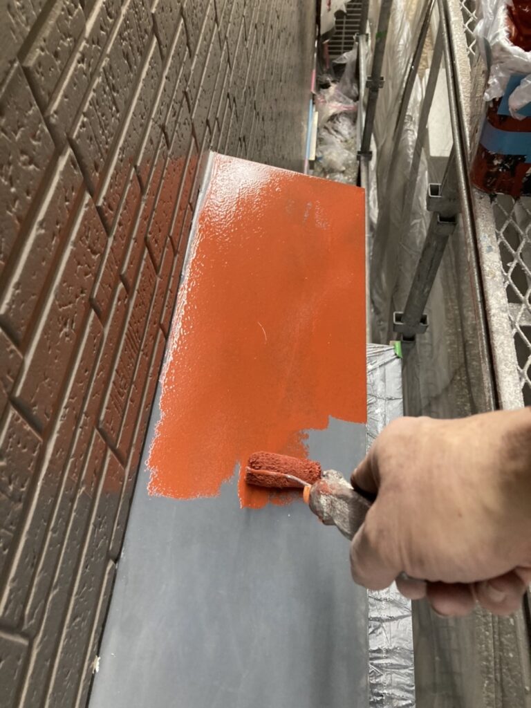 庇に錆止め塗料を施工している様子