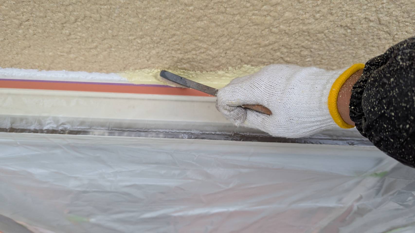 軒ぎわを刷毛で丁寧に塗るダメ込み作業